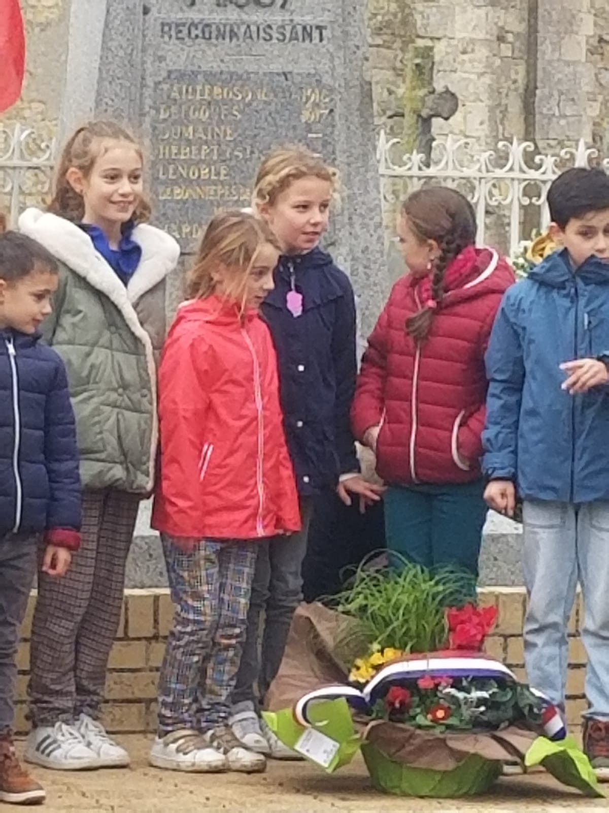 Depot de la gerbe par les enfants devent le monument aux morts