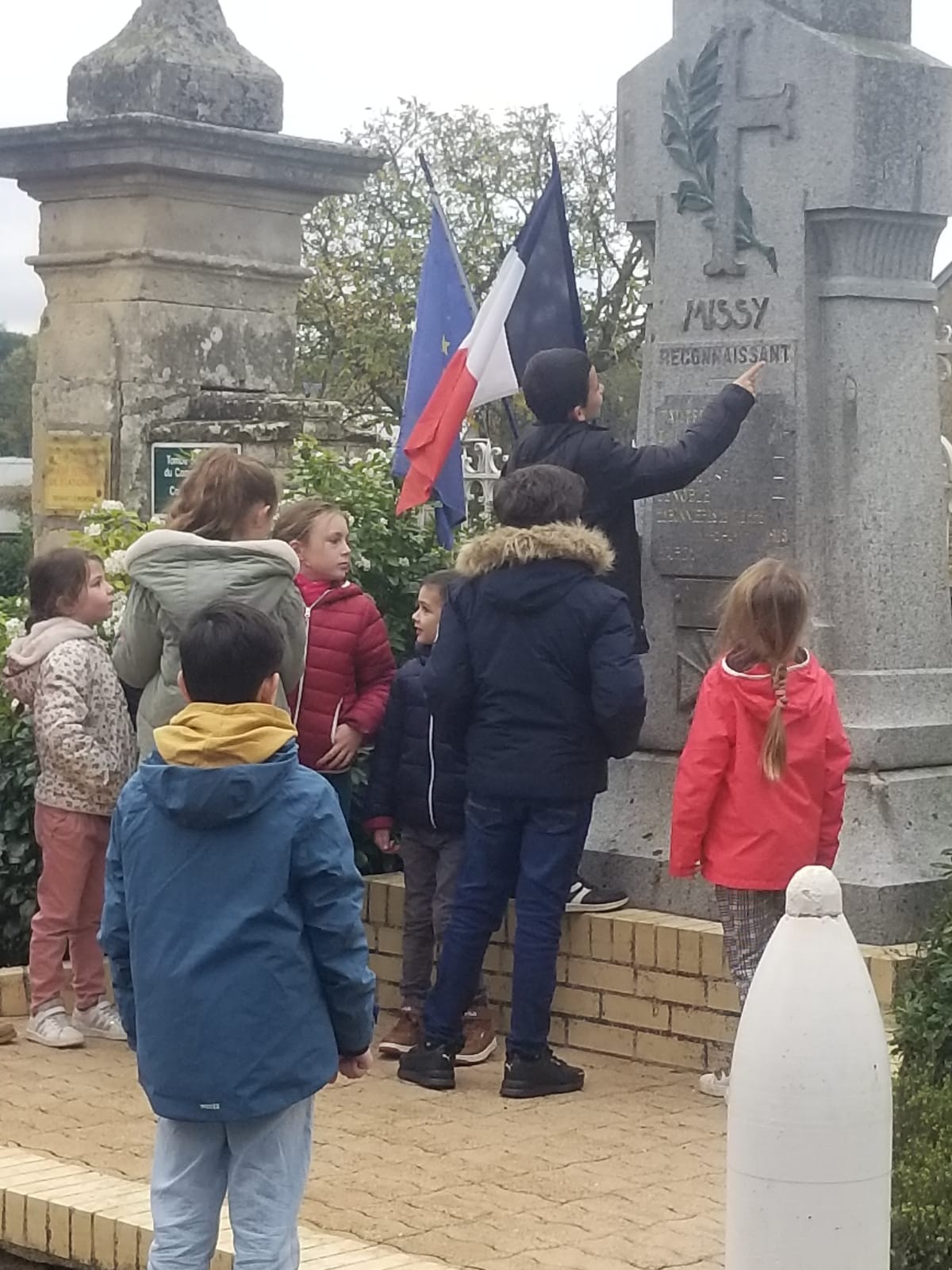 Enfants de l ecole devant monument aux morts de missy